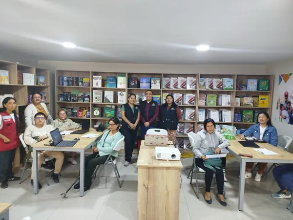 Participantes trabajando en computadoras durante un taller en una biblioteca