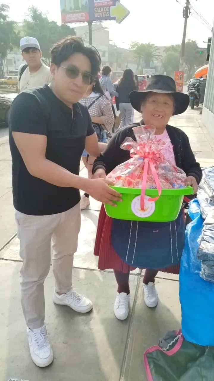 Voluntario de Sin Límites 360 entregando una canasta a una señora durante una campaña